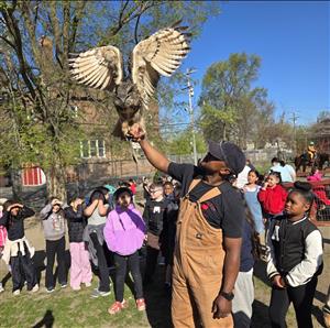 man holding an owl with kids around him
