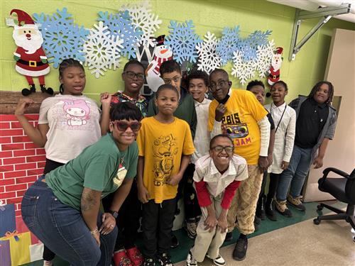  Group picture of students with teachers in a school hallway decorated with snowflakes