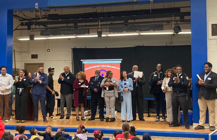  a group of professionals who came to Hamilton standing on a stage