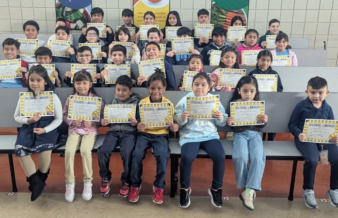 Students sitting with student of the month certificates and smiling