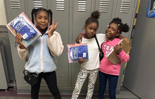  three students standing with books and backpack 