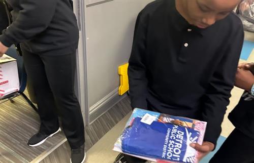 student standing with his backpack and books