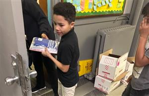 student receiving his backpack and books