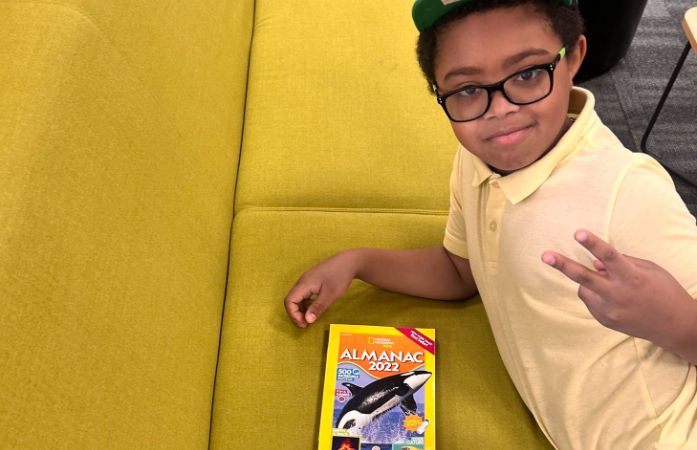  student poses with book