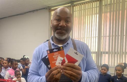  Principal Cannon posing with gift cards from the staff