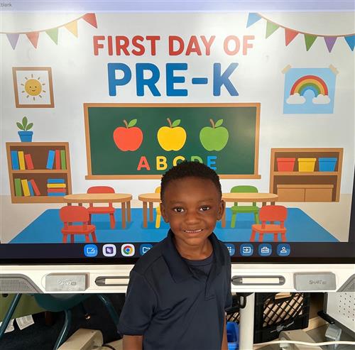 prek student posing in front of poster