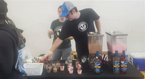 2 people at a table with milk samples to pass out