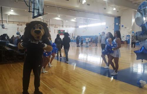 Roary and cheerleaders greeting students as they enter the gym