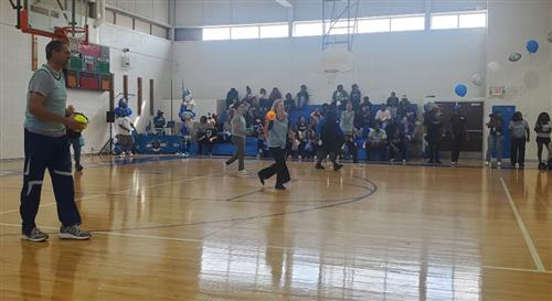 people holding a small ball as the play dodgeball in a gym
