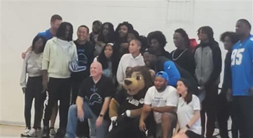 people posing with Detroit Lions Mascot Roary