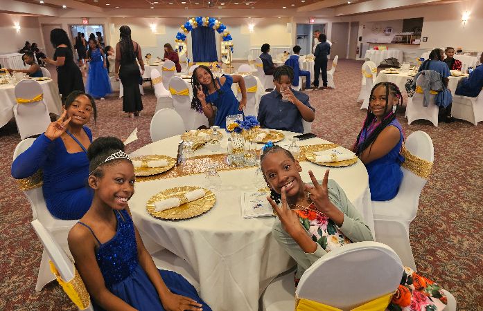 children dress beautifully and sitting at a fancy table