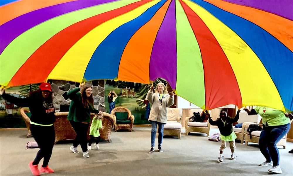  people playing with a parachute 
