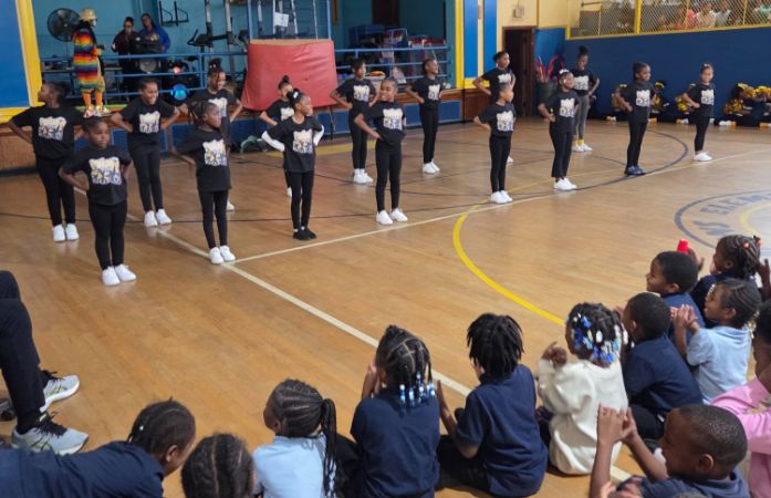  Lower elementary cheerleaders stand in formation.