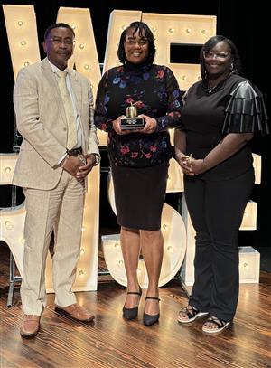 Principal Clayton holds her Principal of the Year award as she stands next to AP Mr. Davis and Ms. Mason