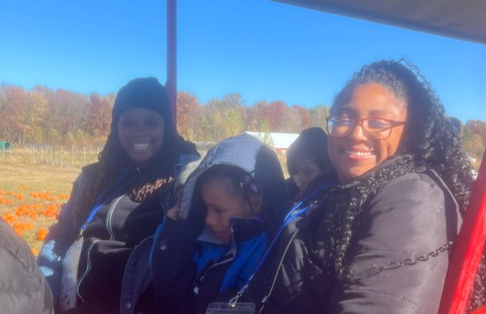  Two women smiling, with a young girl between them.