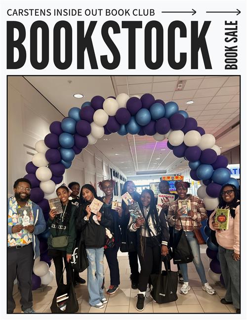  A group of individuals posing with books in front of balloons. 