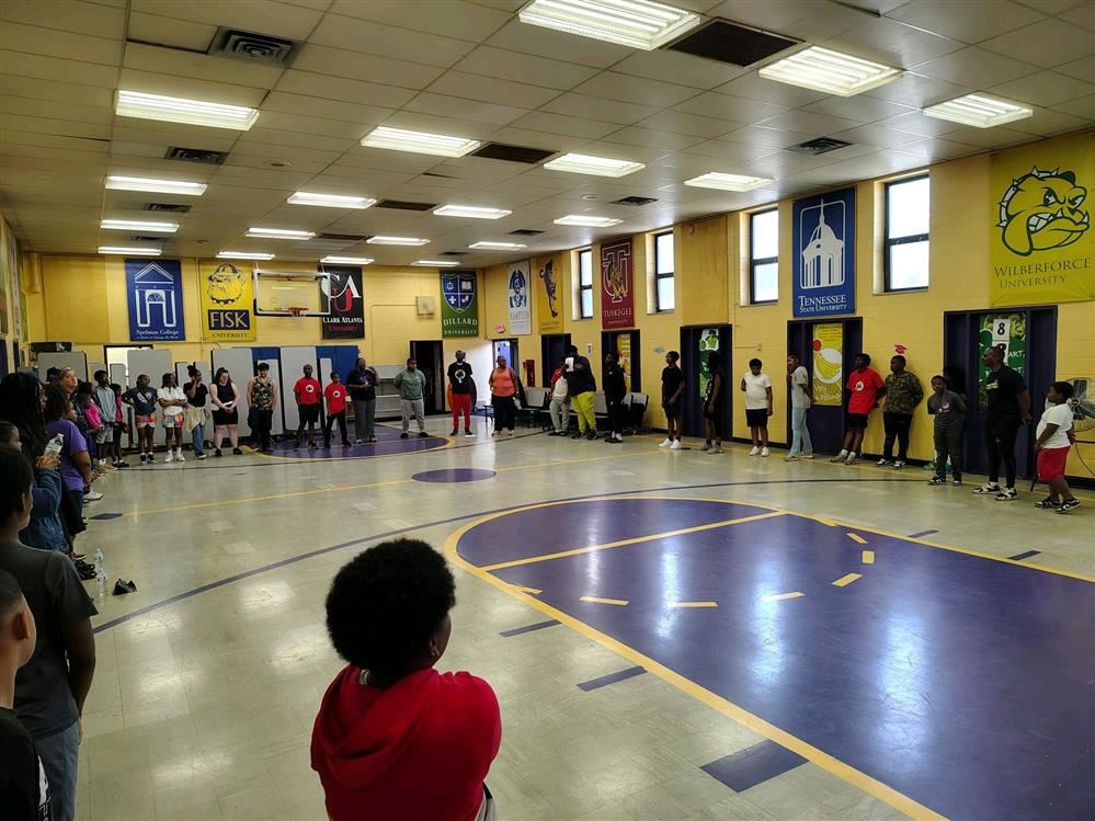  Many students standing in a gym.