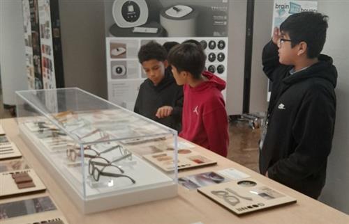 3 students looking at a display of art