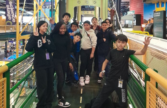  sixth graders standing in a group on a bridge in the science center
