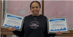  teacher holding two awards