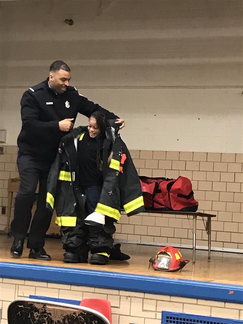 student putting on firefighter suit