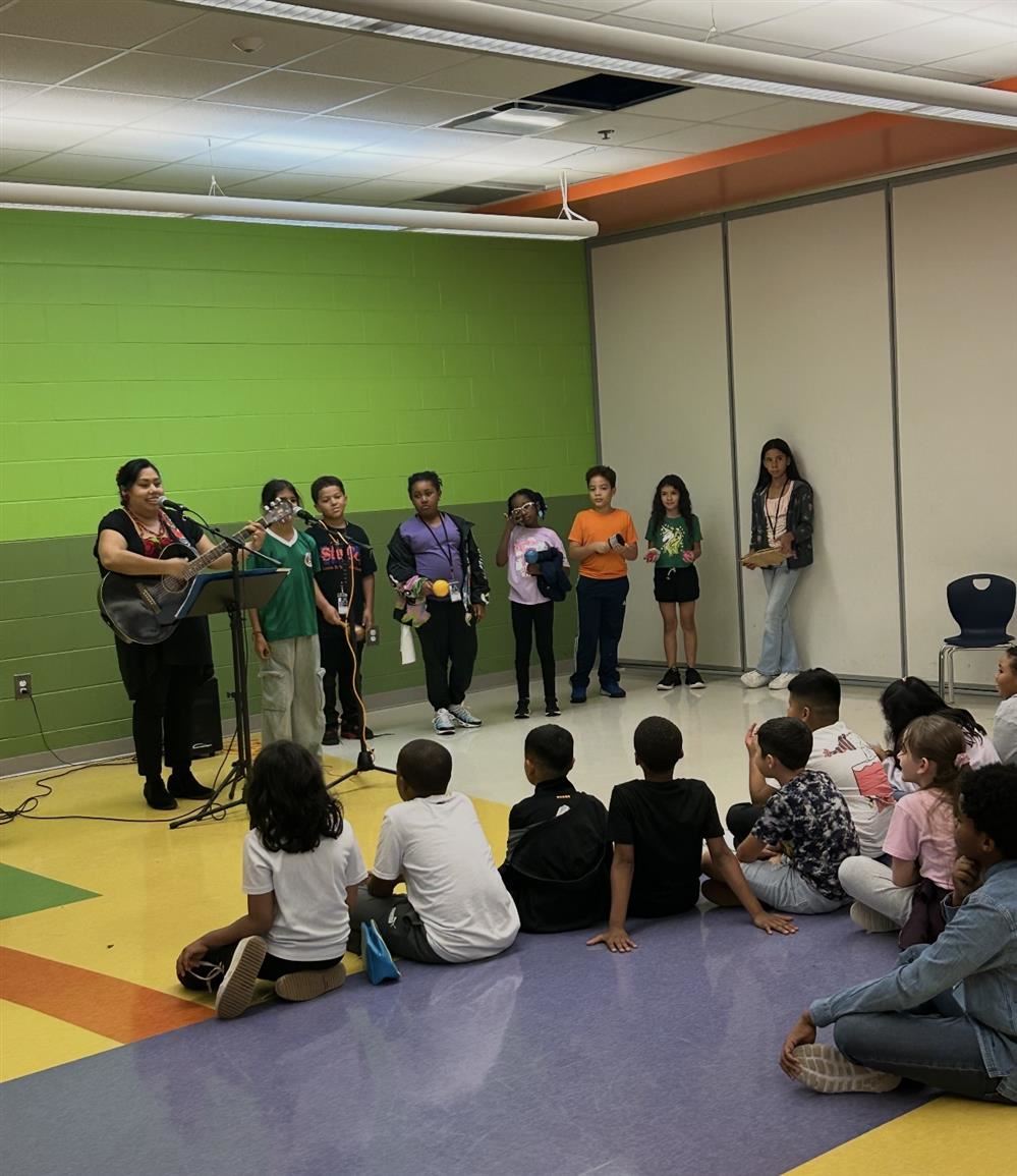  woman playing guitar with children watching