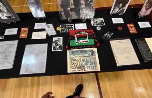 A black table with black history artifacts displayed