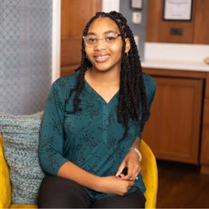 Teenager girl sitting in a chair smiling